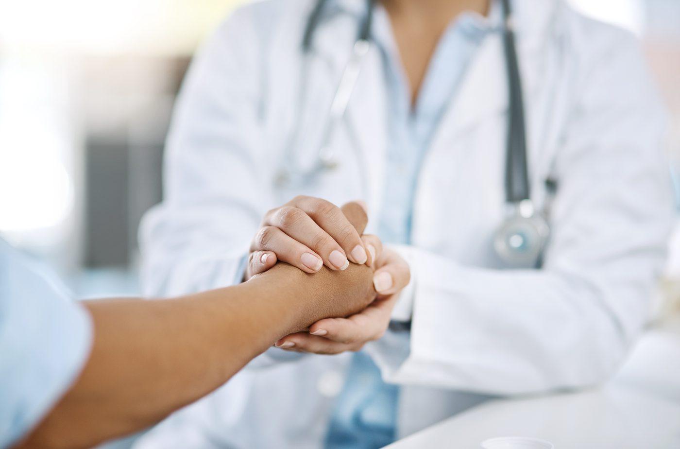 Physician hands clasping patient hands — Metamed whole-person care
